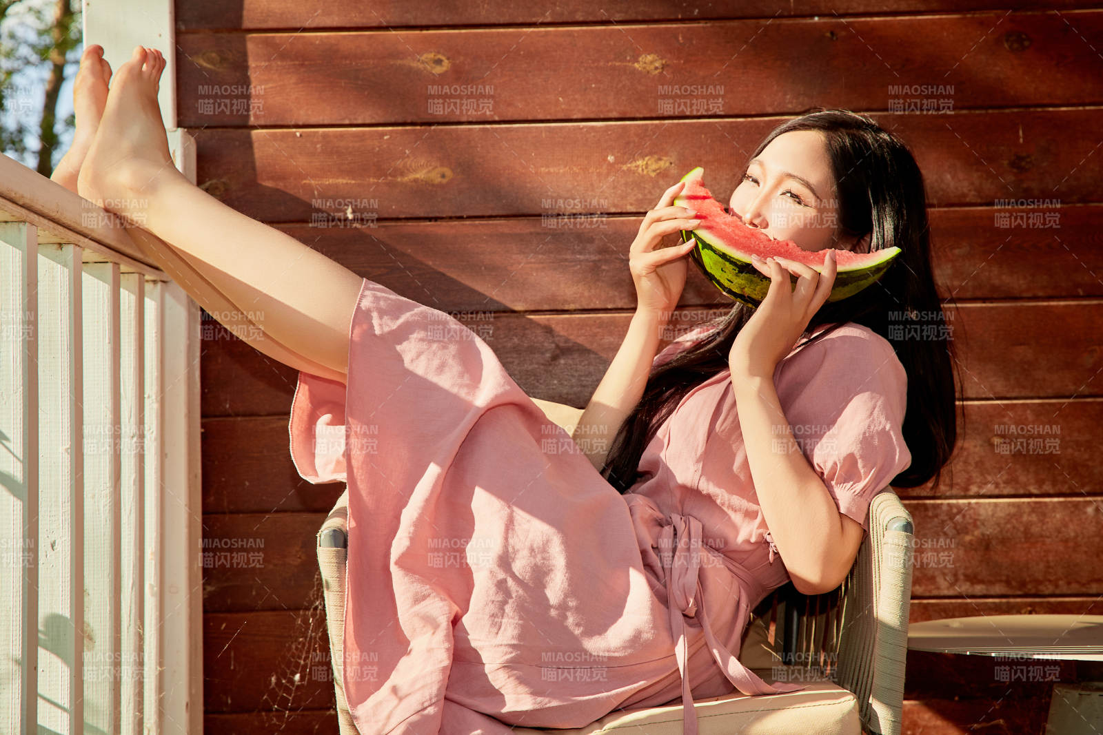 夏天在木质别墅门廊外吃西瓜的美女图片