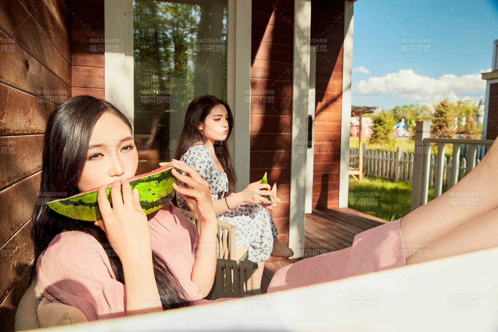 夏天在木质别墅门廊外吃西瓜的美女图片