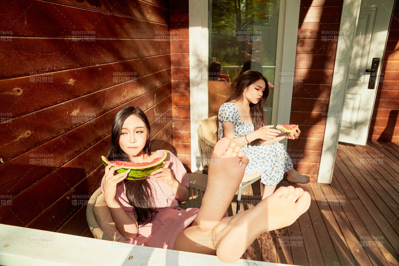 夏天在木质别墅门廊外吃西瓜的美女图片