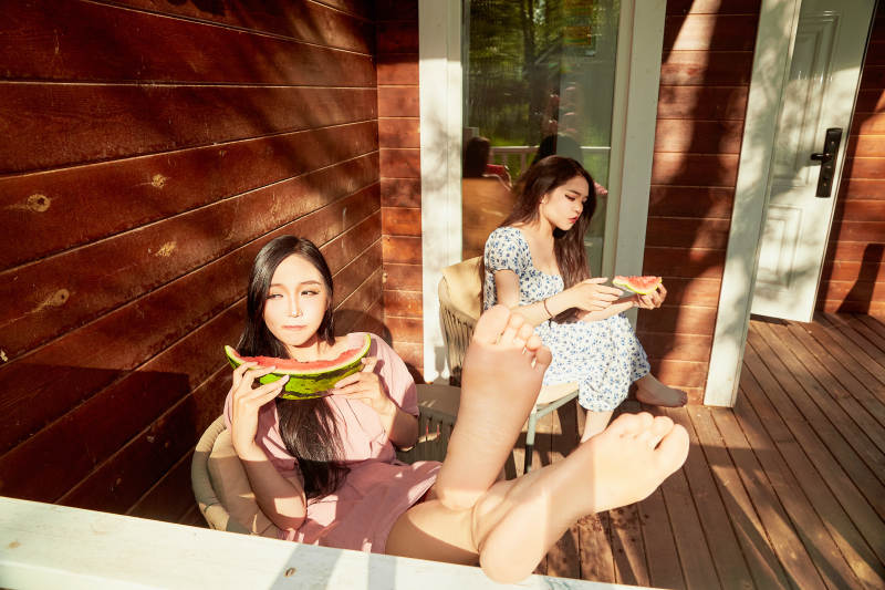 夏天在木质别墅门廊外吃西瓜的美女图片