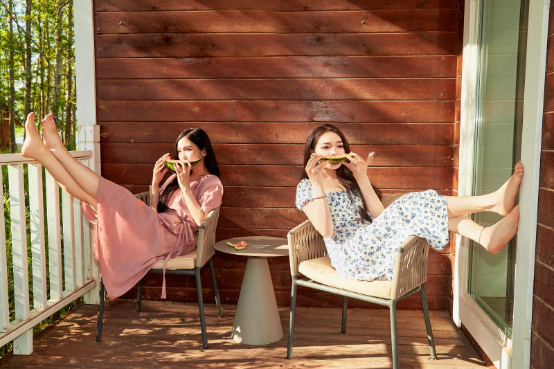 夏天在木质别墅门廊外吃西瓜的美女图片