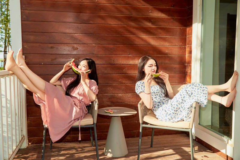 夏天在木质别墅门廊外吃西瓜的美女图片