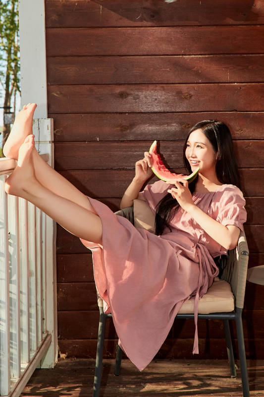 夏天在木质别墅门廊外吃西瓜的美女图片