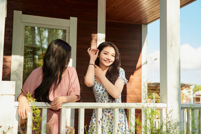 夏天在别墅门庭外拍照欣赏风景的亚洲美女图片