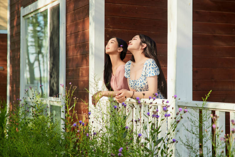 夏天在别墅门庭外拍照欣赏风景的亚洲美女图片