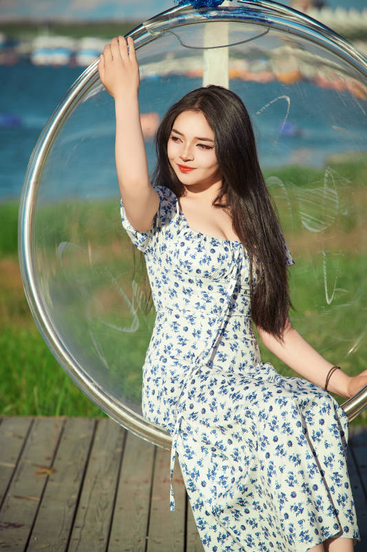 草原湖畔打卡点游玩拍照的东方美女图片