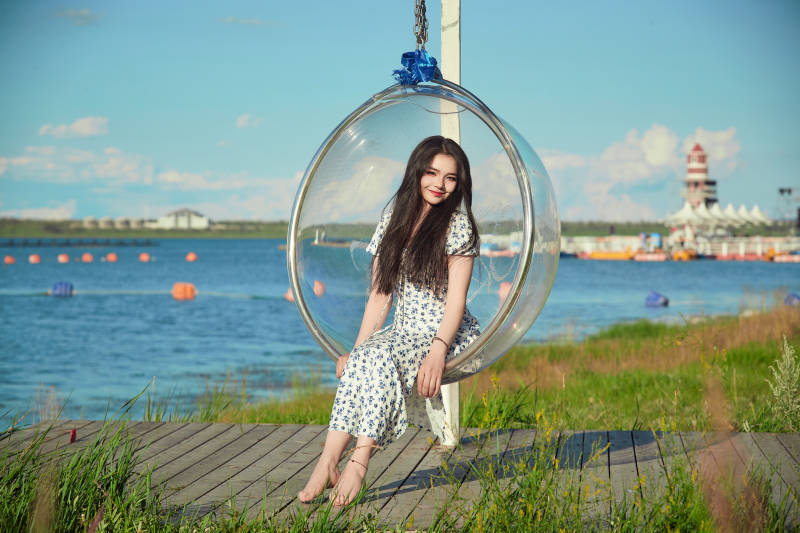 草原湖畔打卡点游玩拍照的东方美女图片