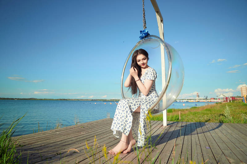 草原湖畔打卡点游玩拍照的东方美女图片