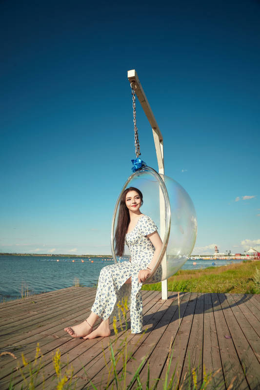 草原湖畔打卡点游玩拍照的东方美女图片