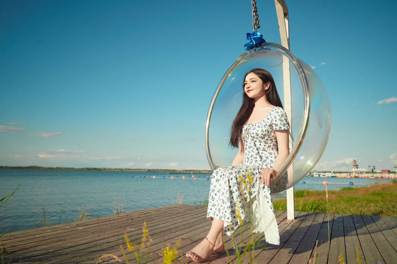 草原湖畔打卡点游玩拍照的东方美女图片