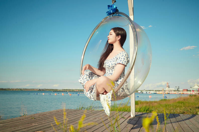 草原湖畔打卡点游玩拍照的东方美女图片