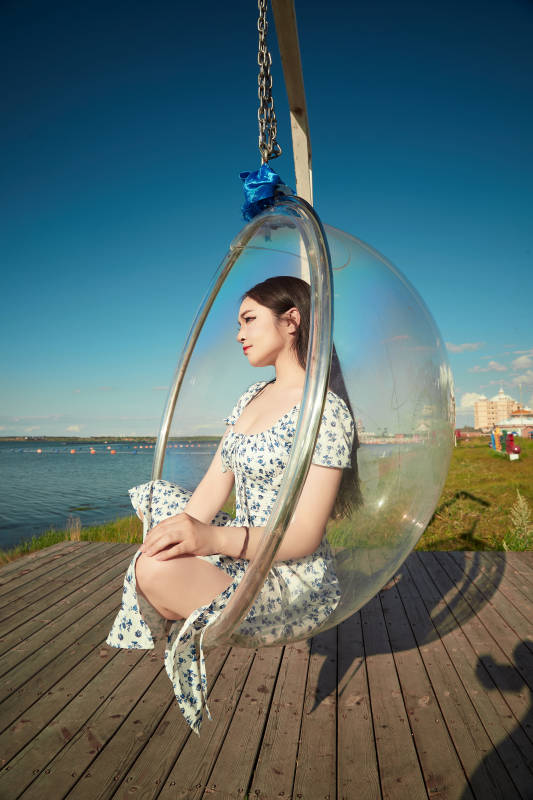 草原湖畔打卡点游玩拍照的东方美女图片