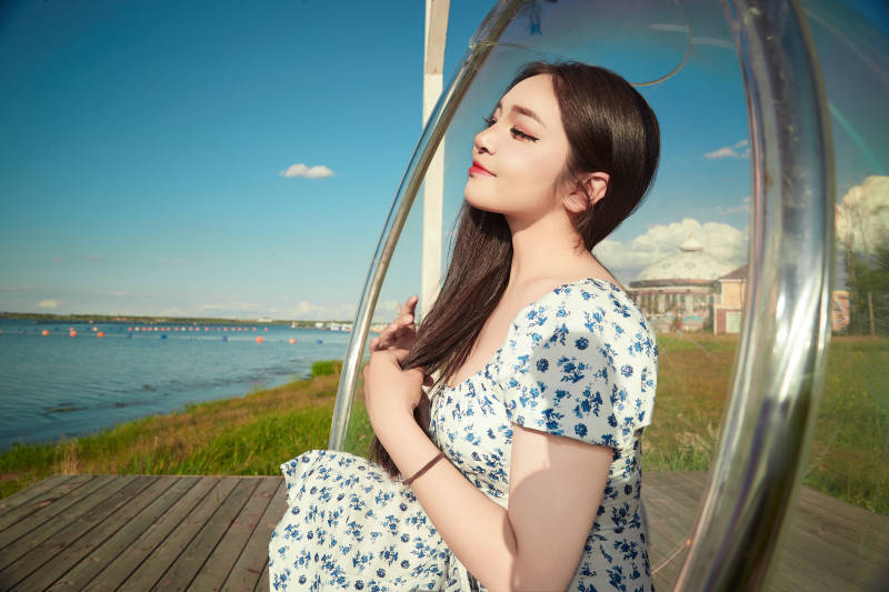 草原湖畔打卡点游玩拍照的东方美女图片