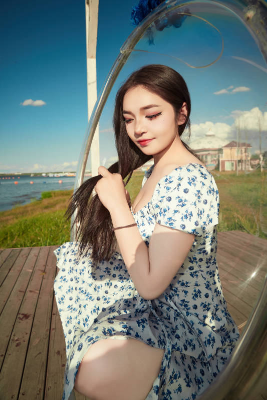 草原湖畔打卡点游玩拍照的东方美女图片