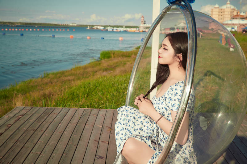 草原湖畔打卡点游玩拍照的东方美女图片