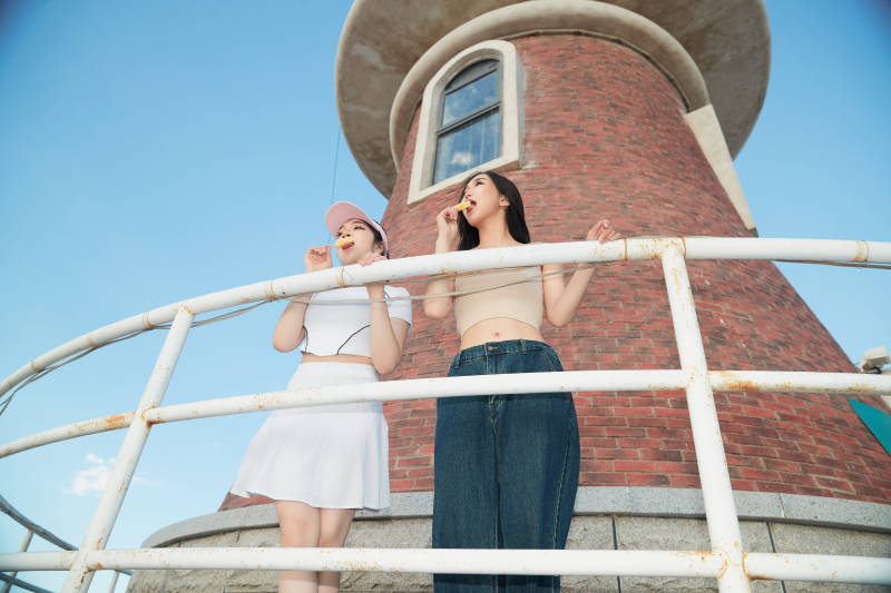 盛夏在景区湖边灯塔上拍照游玩的美女们图片