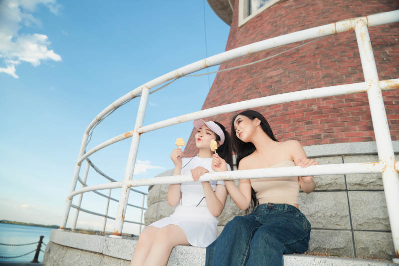 盛夏在景区湖边灯塔上拍照游玩的美女们图片