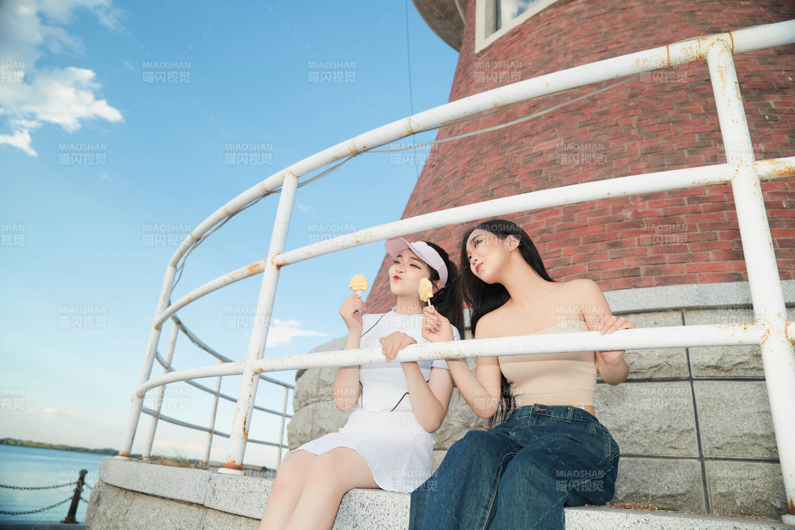 盛夏在景区湖边灯塔上拍照游玩的美女们图片