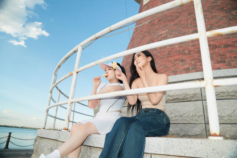 盛夏在景区湖边灯塔上拍照游玩的美女们图片