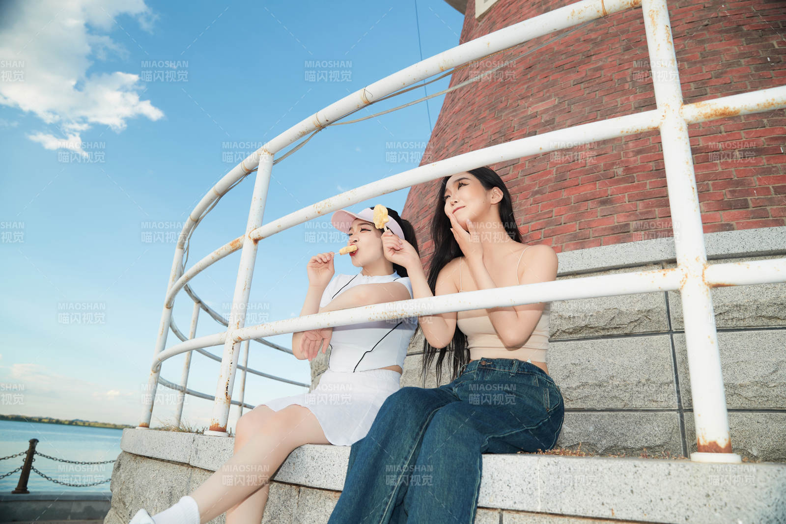 盛夏在景区湖边灯塔上拍照游玩的美女们图片