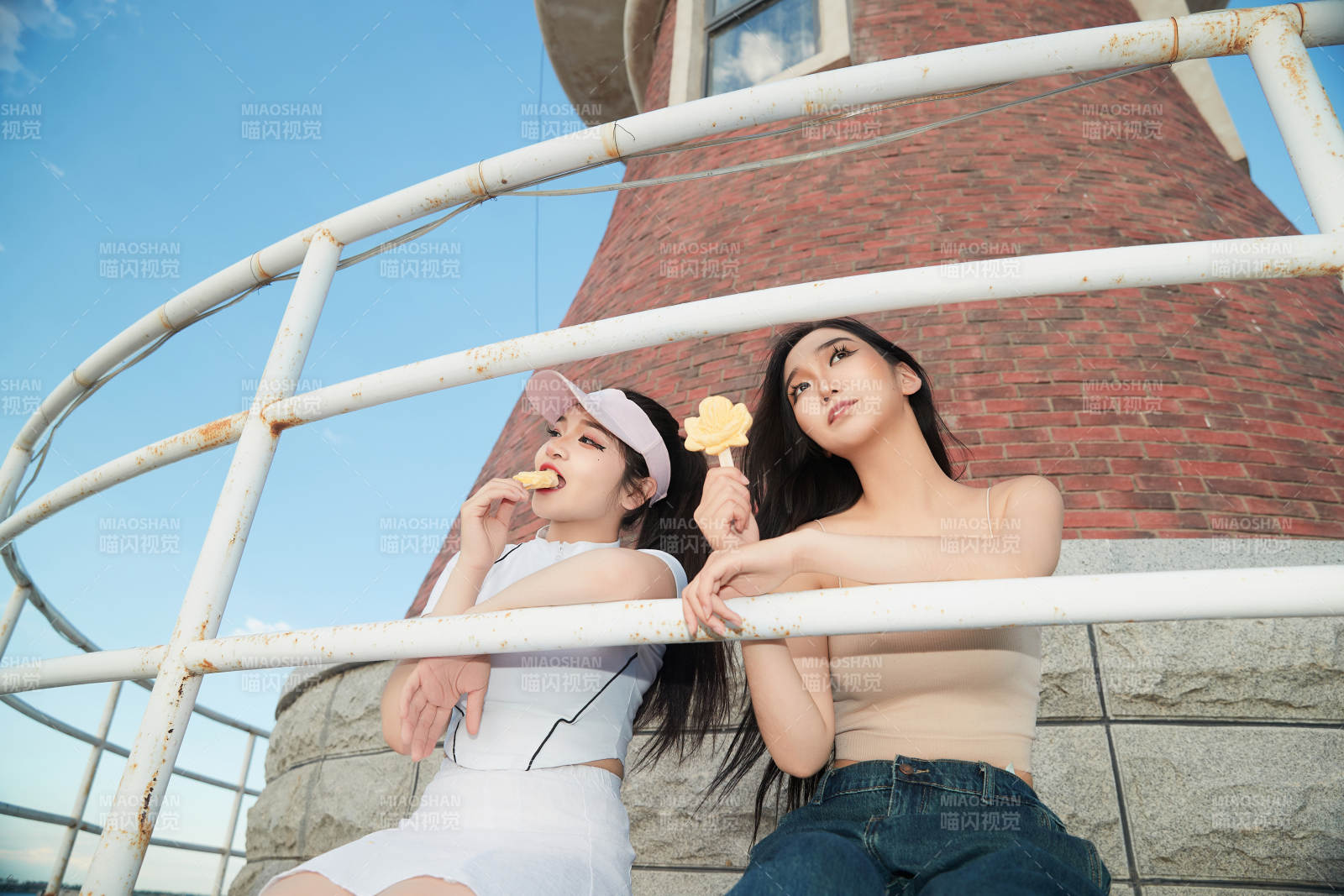 盛夏在景区湖边灯塔上拍照游玩的美女们图片