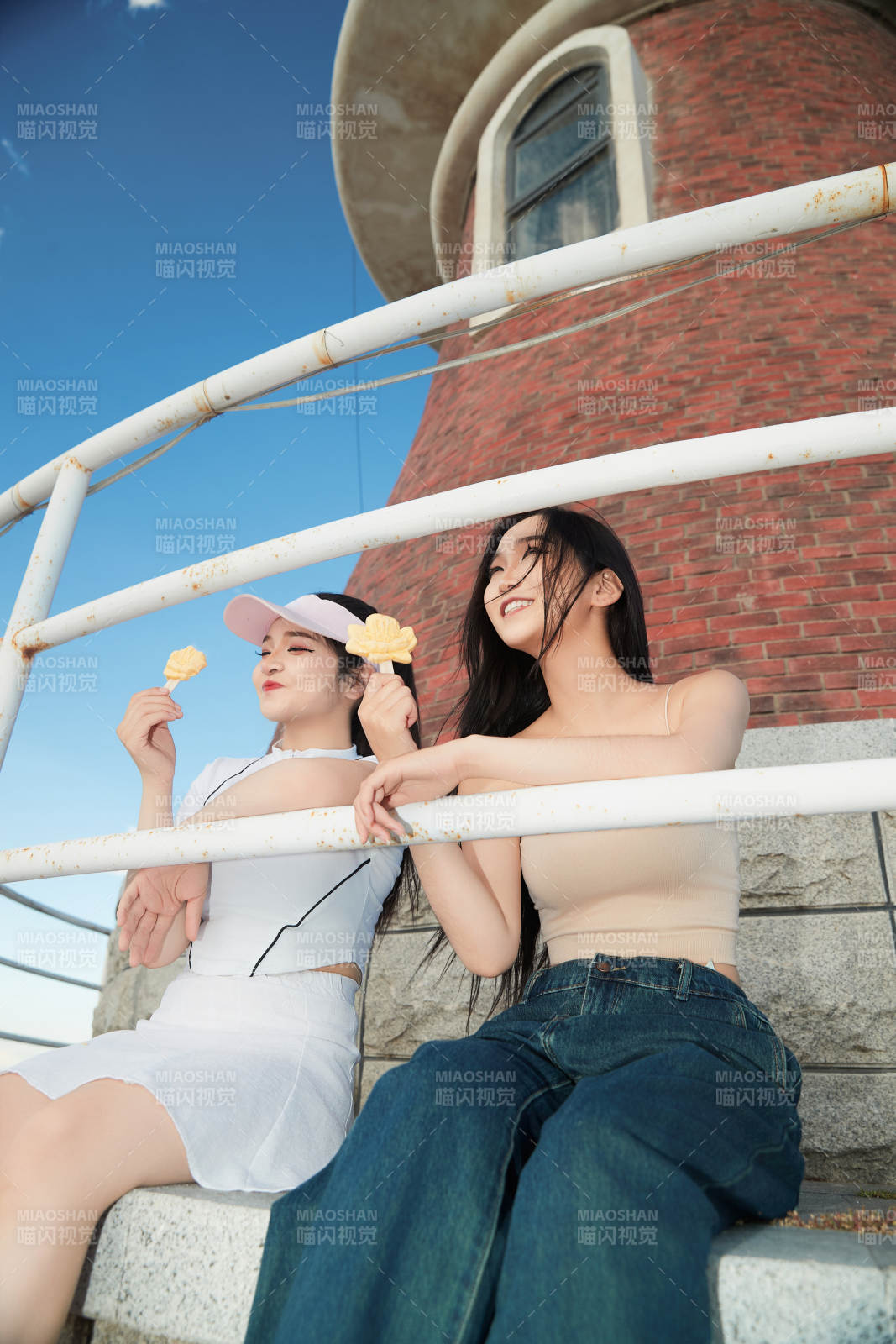 盛夏在景区湖边灯塔上拍照游玩的美女们图片