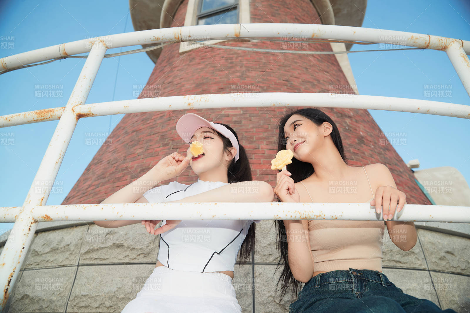 盛夏在景区湖边灯塔上拍照游玩的美女们图片