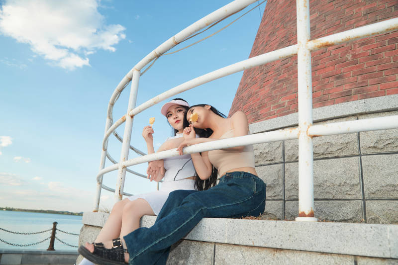 盛夏在景区湖边灯塔上拍照游玩的美女们图片