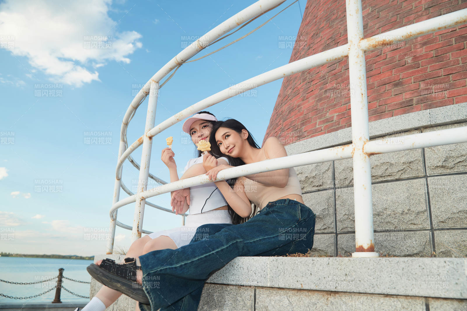 盛夏在景区湖边灯塔上拍照游玩的美女们图片