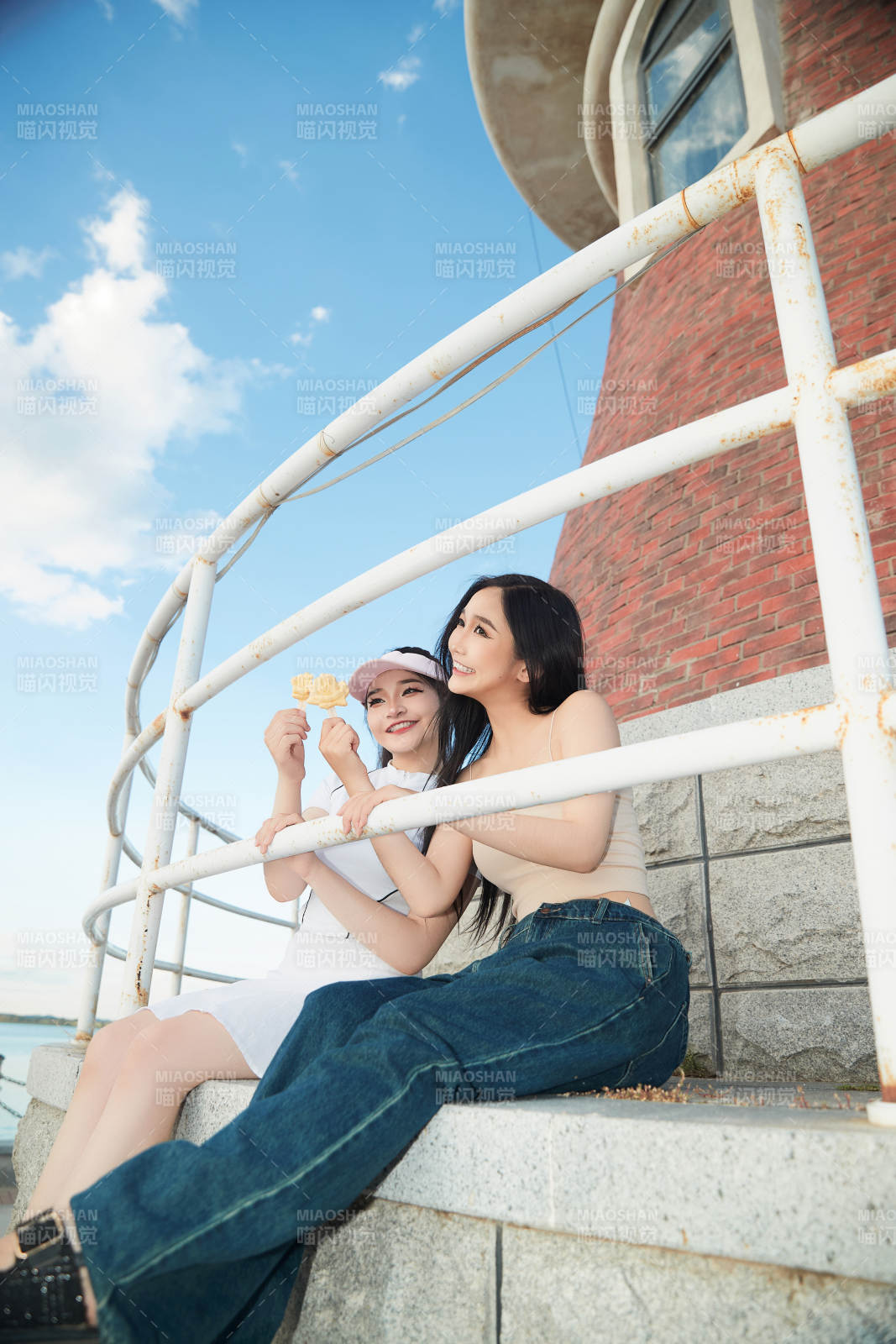 盛夏在景区湖边灯塔上拍照游玩的美女们图片