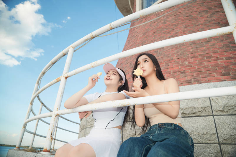 盛夏在景区湖边灯塔上拍照游玩的美女们图片