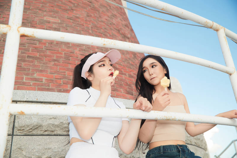 盛夏在景区湖边灯塔上拍照游玩的美女们图片