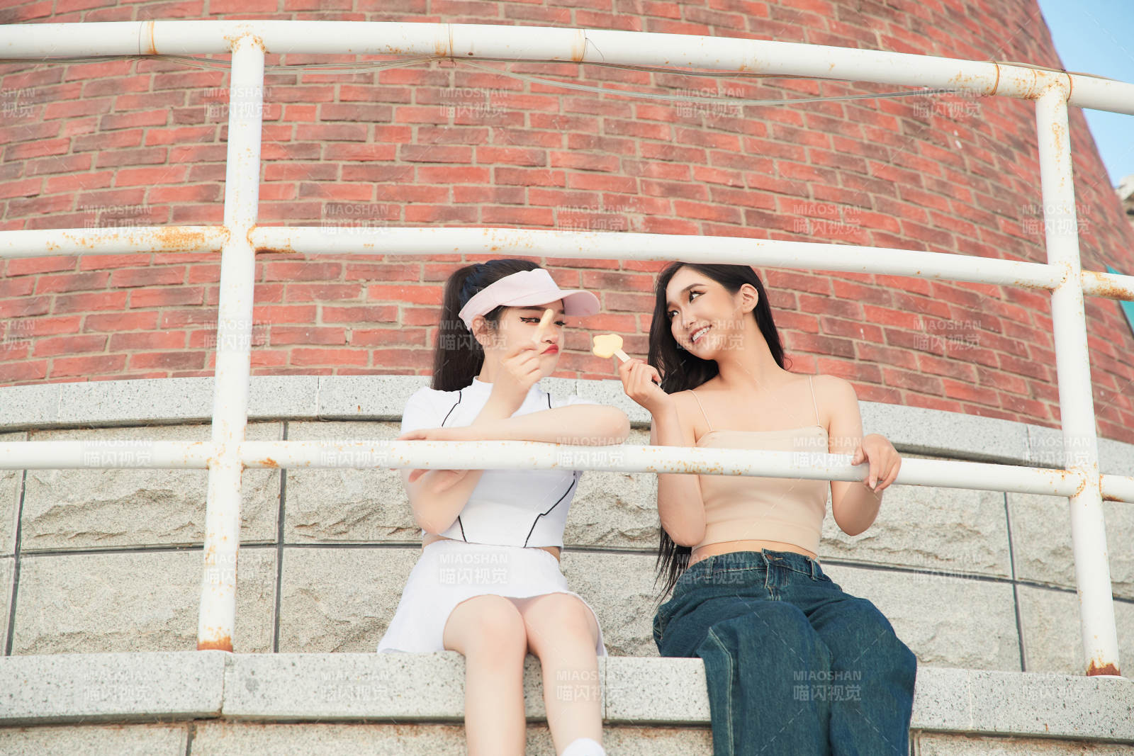 盛夏在景区湖边灯塔上拍照游玩的美女们图片