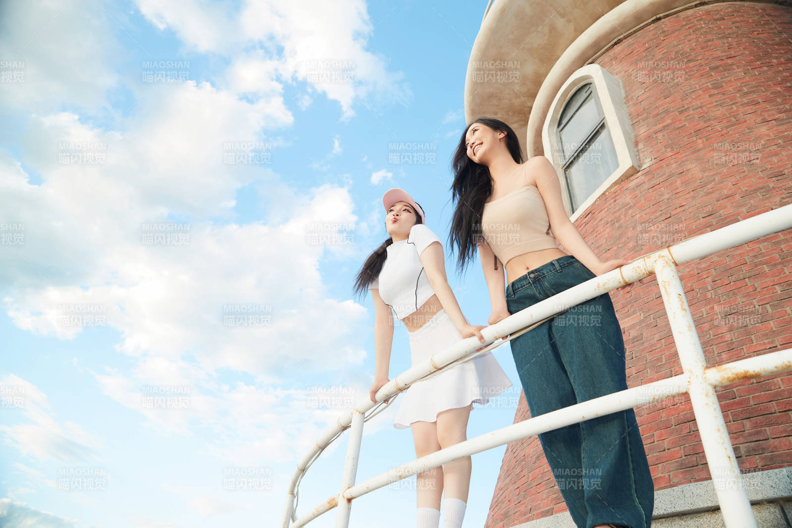 盛夏在景区湖边灯塔上拍照游玩的美女们图片