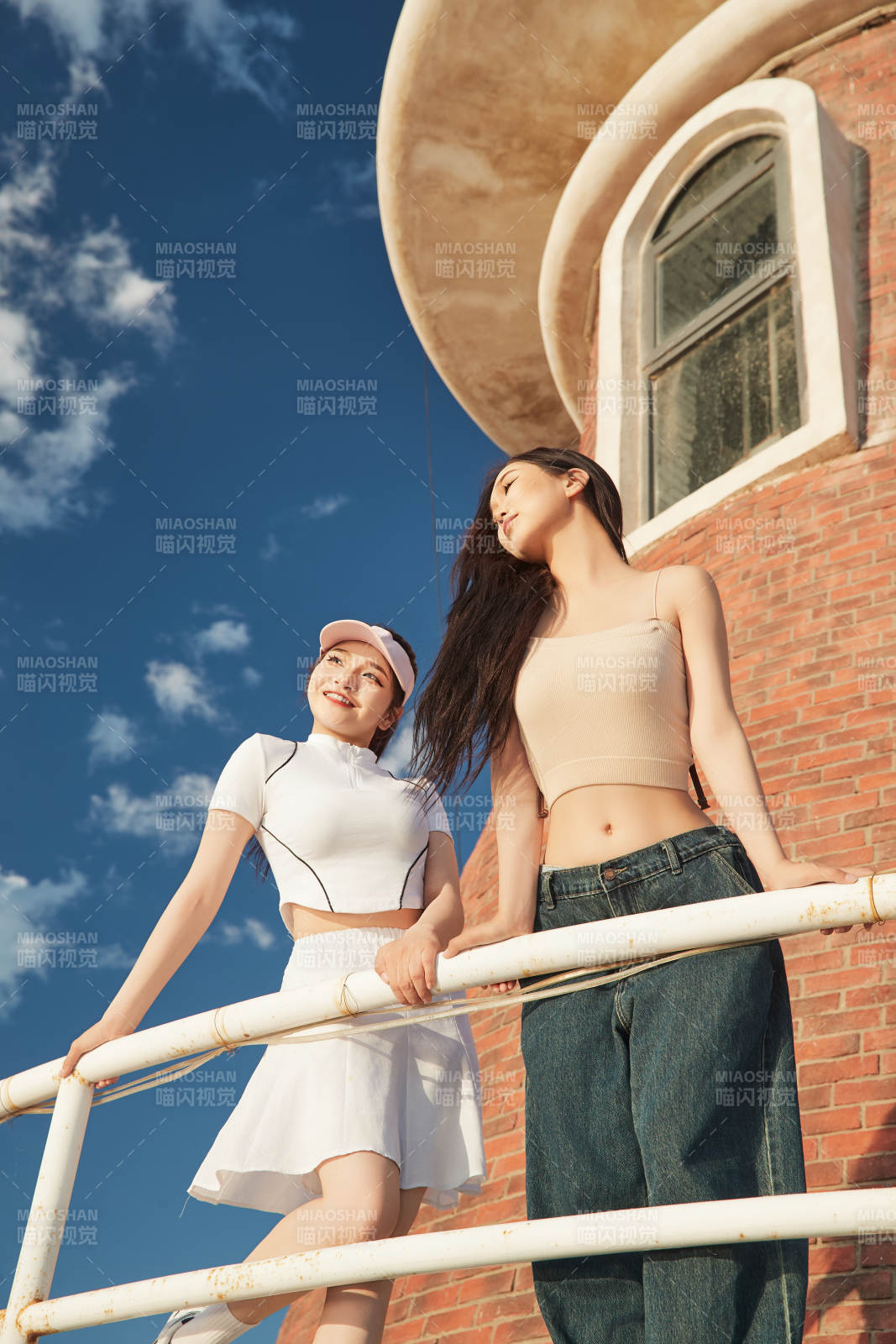 盛夏在景区湖边灯塔上拍照游玩的美女们图片