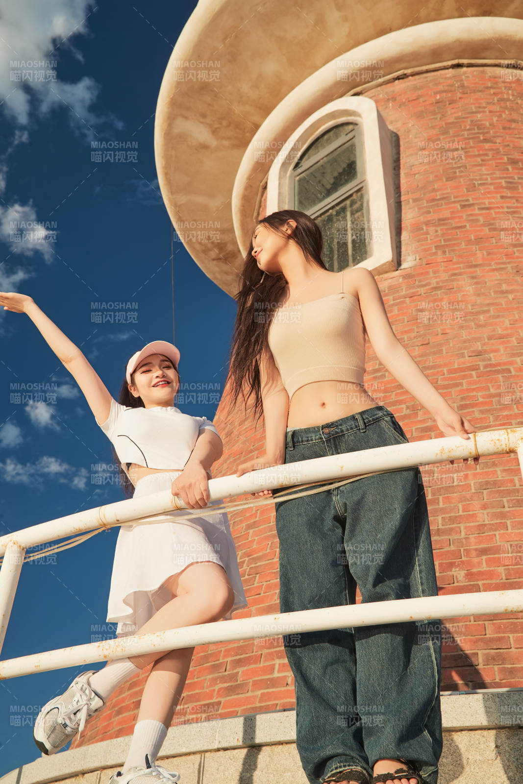 盛夏在景区湖边灯塔上拍照游玩的美女们图片