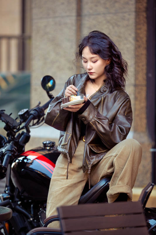 户外在复古机车上品尝甜点的亚洲美女图片