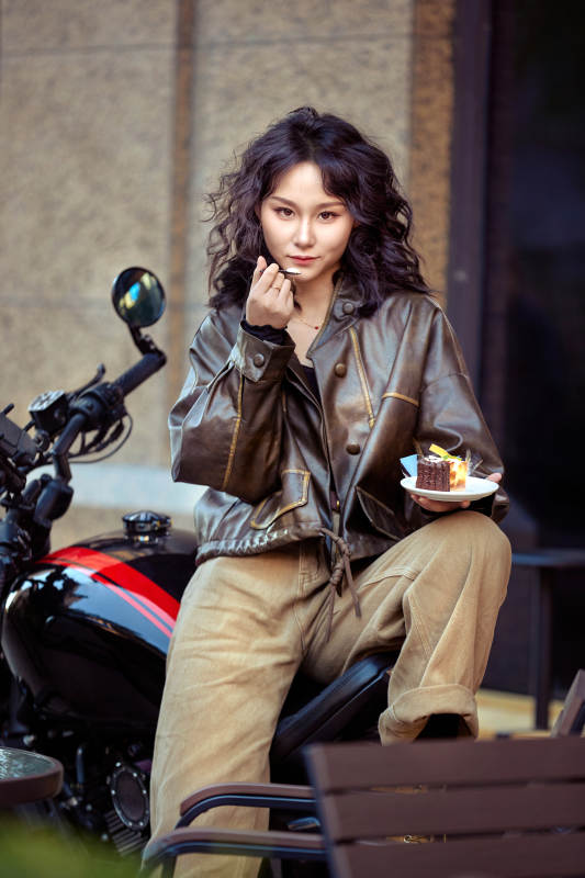 户外在复古机车上品尝甜点的亚洲美女图片