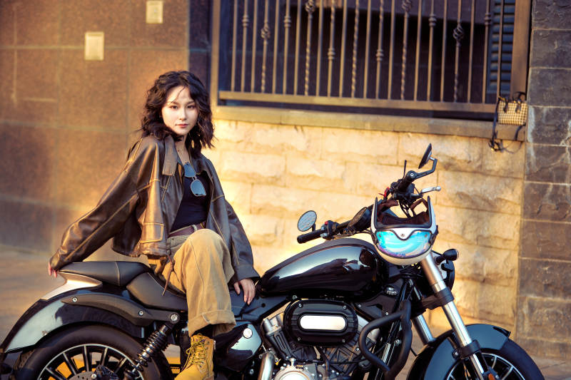 夕阳午后骑复古摩托进行拍照的东方美女图片