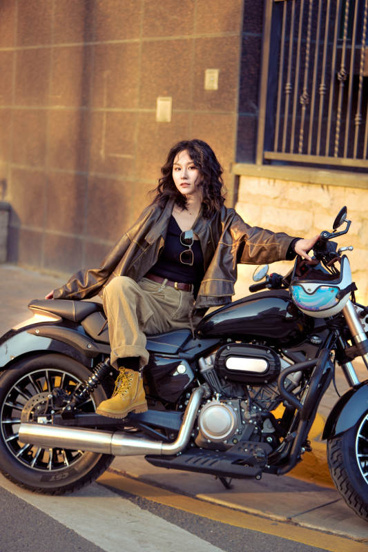 夕阳午后骑复古摩托进行拍照的东方美女图片