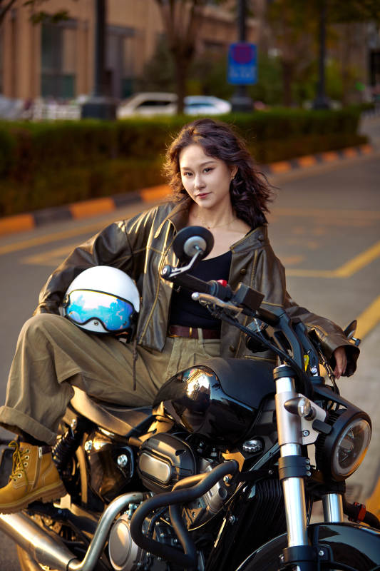夕阳午后骑复古摩托进行拍照的东方美女图片