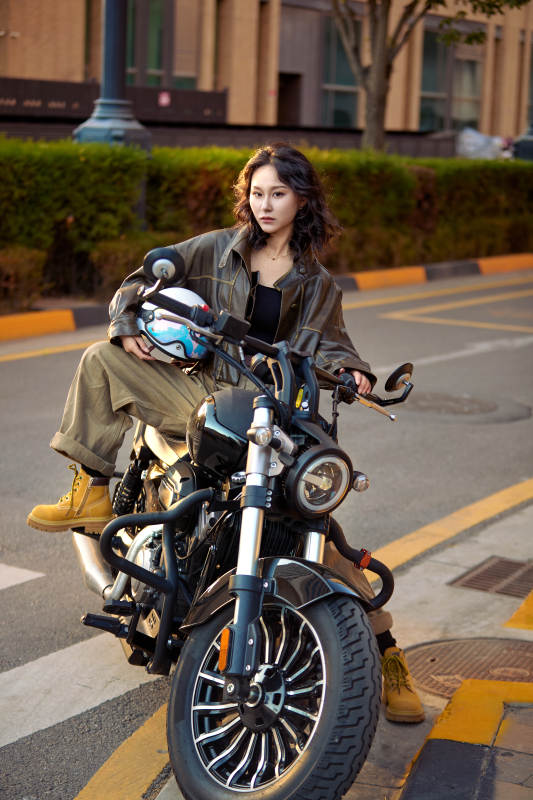 夕阳午后骑复古摩托进行拍照的东方美女图片