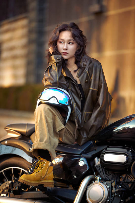 夕阳午后骑复古摩托进行拍照的东方美女图片