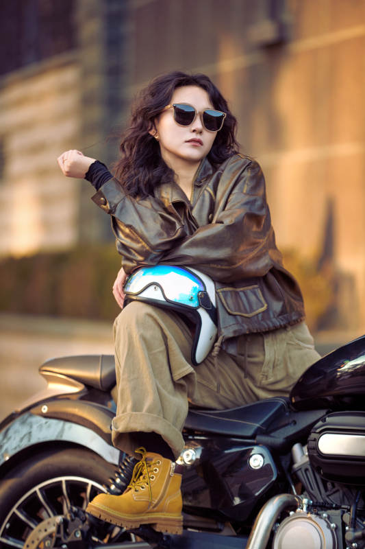 夕阳午后骑复古摩托进行拍照的东方美女图片