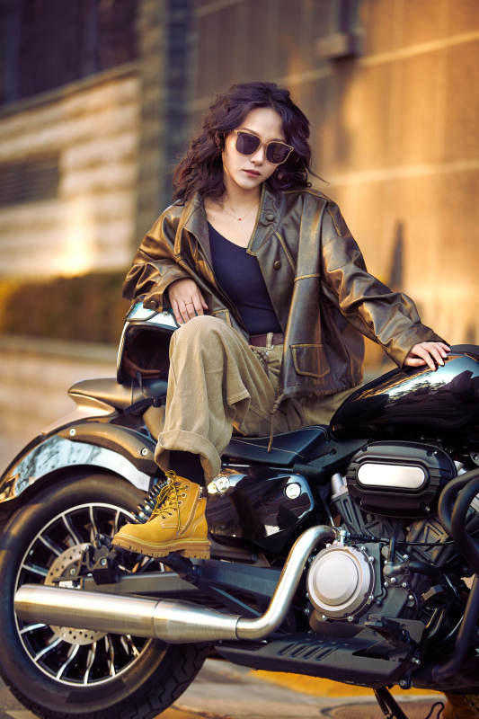 夕阳午后骑复古摩托进行拍照的东方美女图片