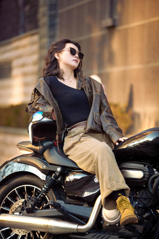 夕阳午后骑复古摩托进行拍照的东方美女图片