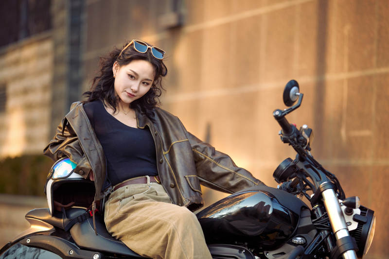 夕阳午后骑复古摩托进行拍照的东方美女图片