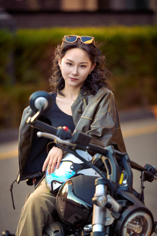 夕阳午后骑复古摩托进行拍照的东方美女图片