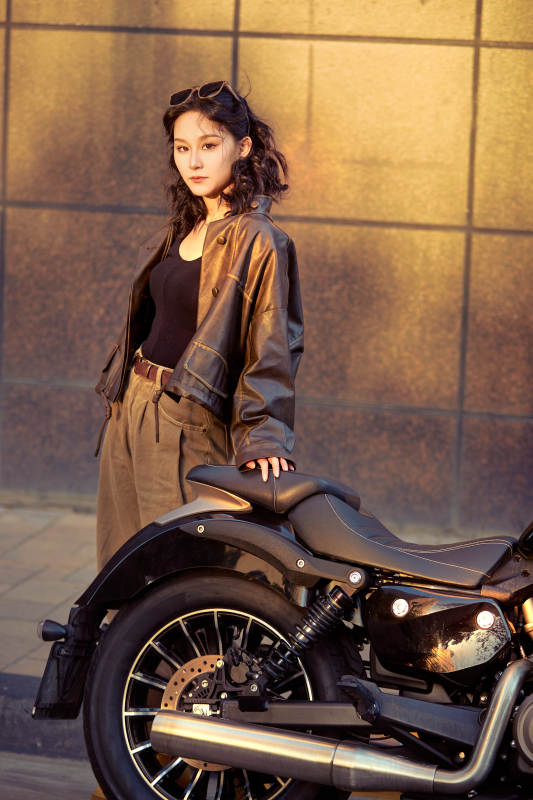 夕阳午后骑复古摩托进行拍照的东方美女图片