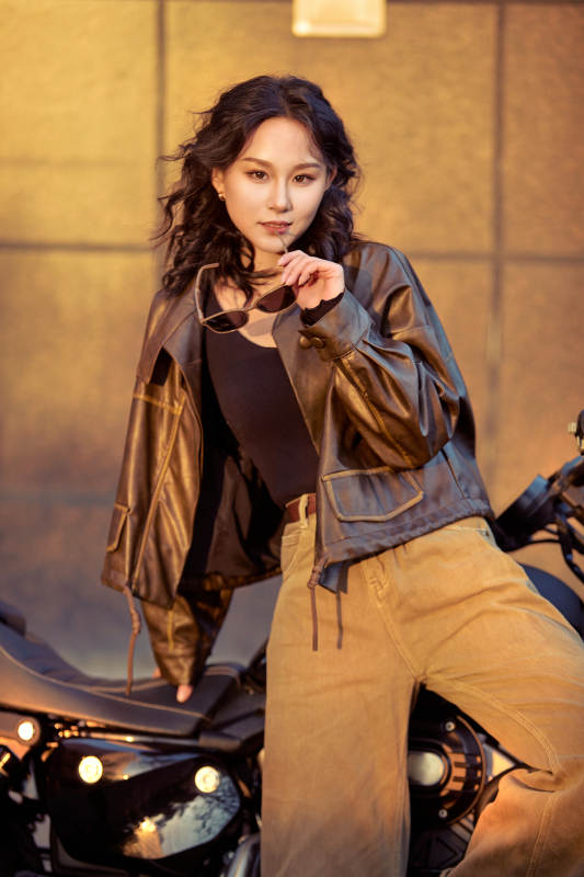 夕阳午后骑复古摩托进行拍照的东方美女图片
